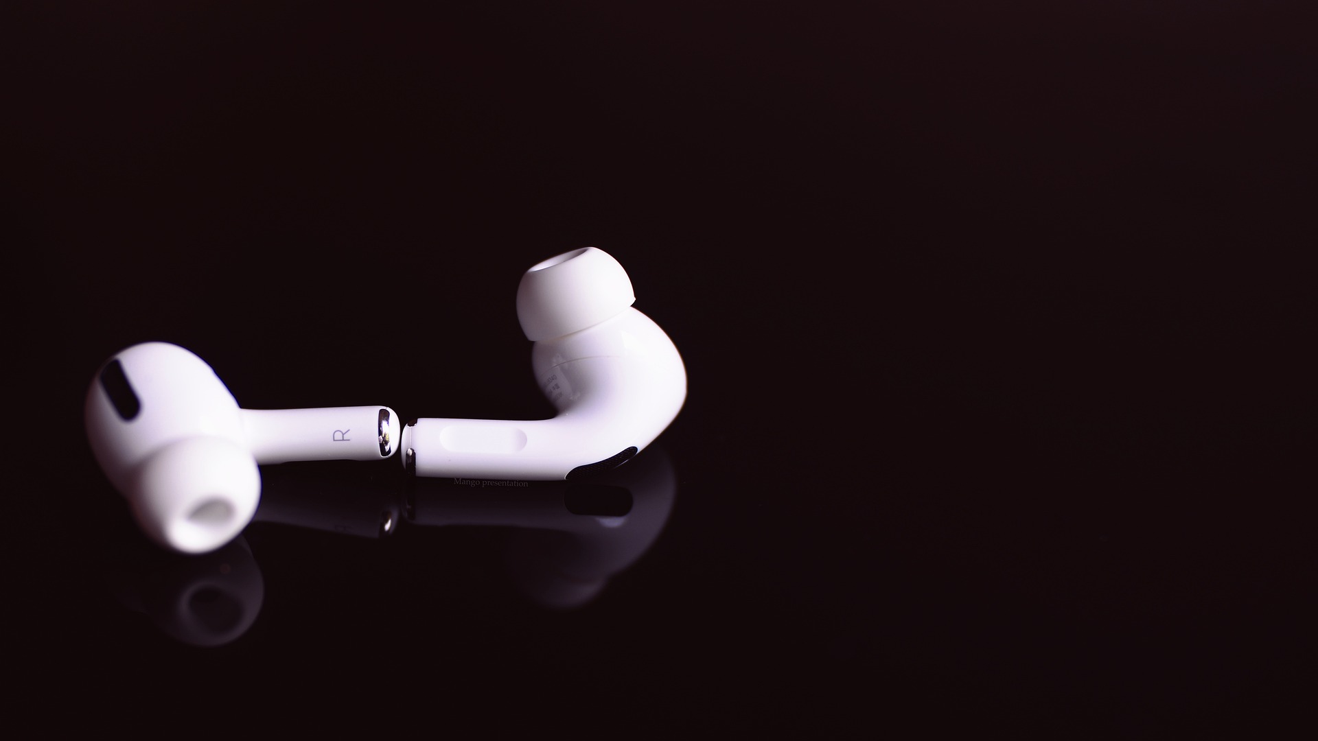 Imagem com um fone de ouvido intra auricular bluetooth branco em um fundo preto